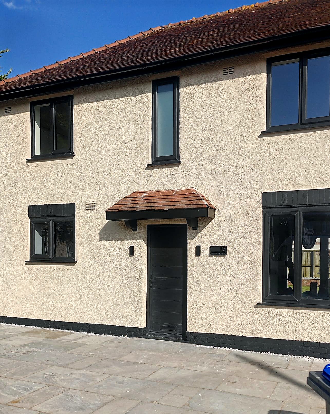 Renovated cottage with fresh render, black windows and new stone patio