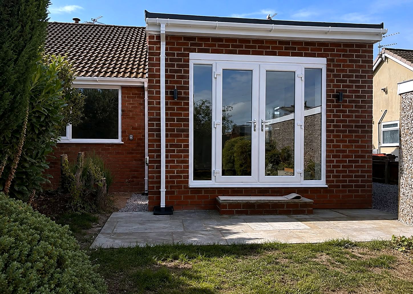 Brick extension with white French doors and stone patio