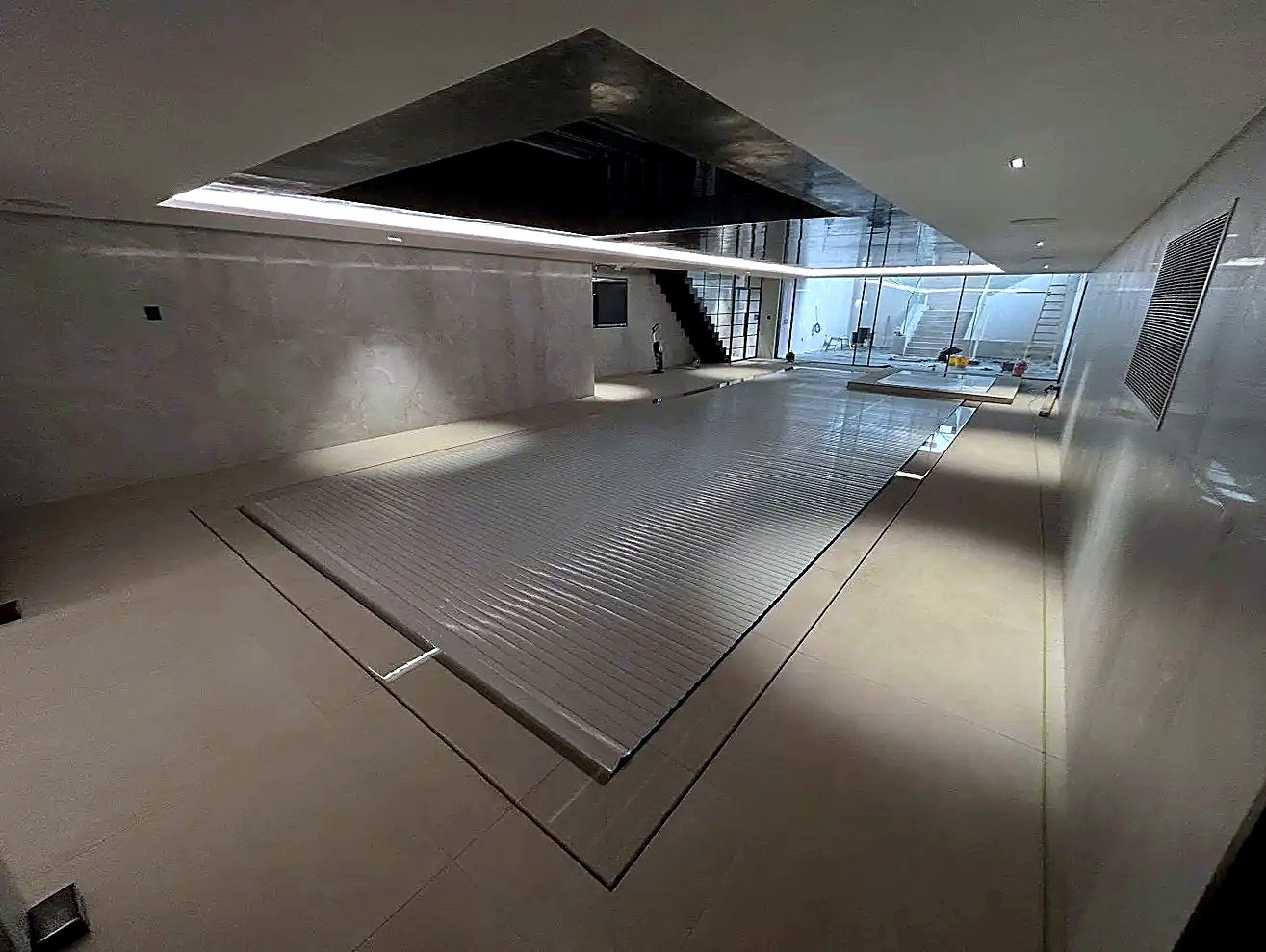 Basement pool with automatic slatted cover and feature lighting